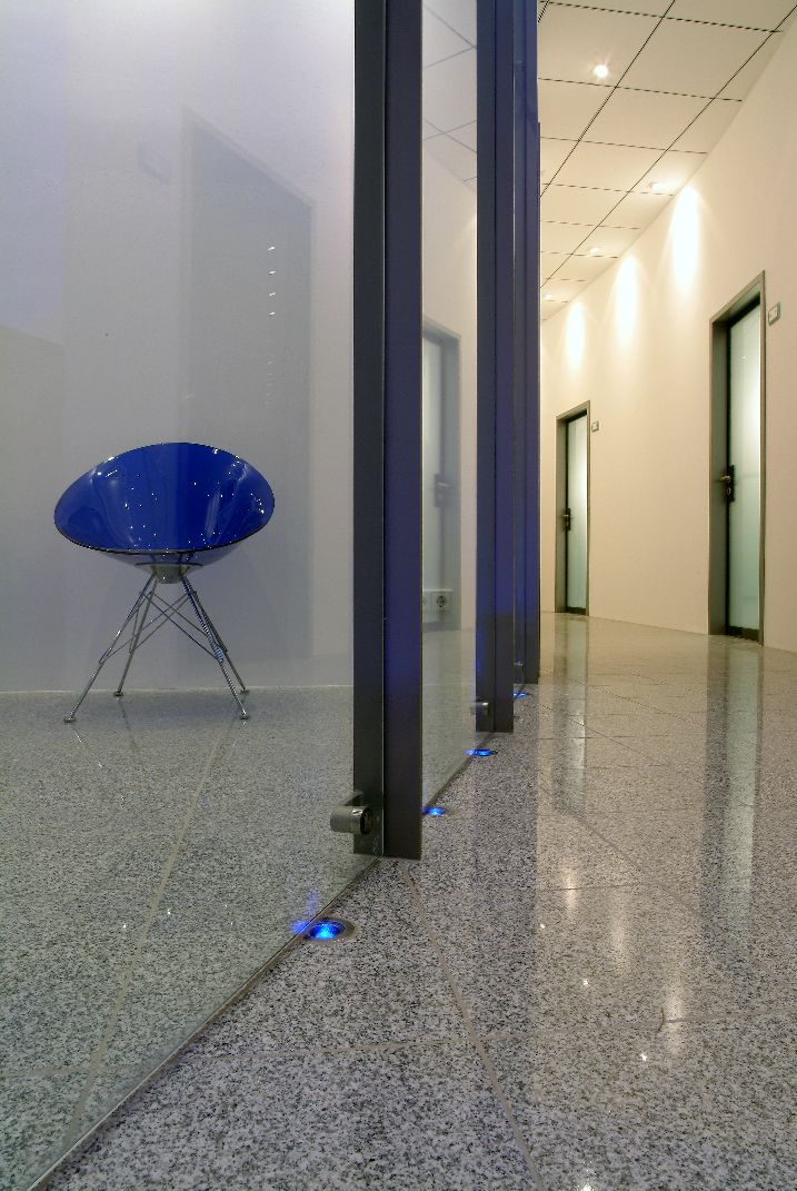 blaue Lampen unter einer Glaswand